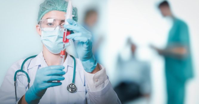 Lab Scientist or Female Doctor Medicine Science is Injecting Blood Syringe into Sample Tube for Experiment Biology in Clinic Laboratory. Doctors Team Diagnosing Patient Health in Examination Room