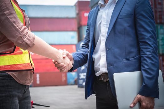 Businessman and Container Shipping Worker Handshake Together for Cooperation Shipment in Logistic Warehouse, Business Partnership Greeting Handshaking After Discussion Containers Transport Dealing.