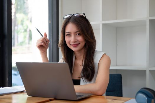 Young pretty asian businesswoman with laptop computer in the office.
