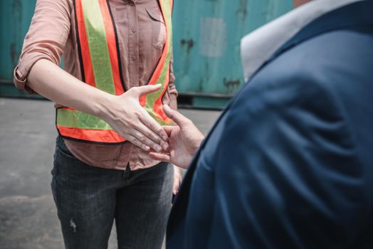 Businessman and Container Shipping Worker Handshake Together for Cooperation Shipment in Logistic Warehouse, Business Partnership Greeting Handshaking After Discussion Containers Transport Dealing.