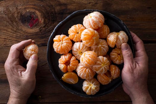 Presentation of Small peeled mandarin oranges on old wooden table