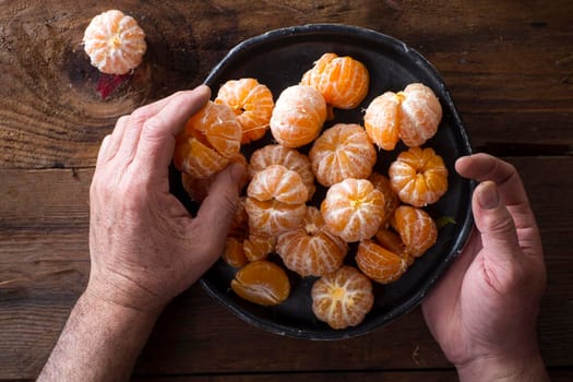 Presentation of Small peeled mandarin oranges on old wooden table