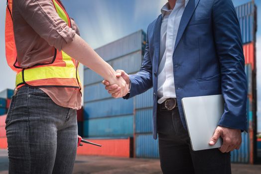 Businessman and Container Shipping Worker Handshake Together for Cooperation Shipment in Logistic Warehouse, Business Partnership Greeting Handshaking After Discussion Containers Transport Dealing.