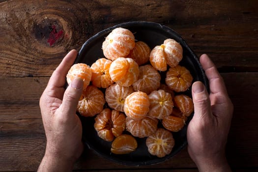 Presentation of Small peeled mandarin oranges on old wooden table