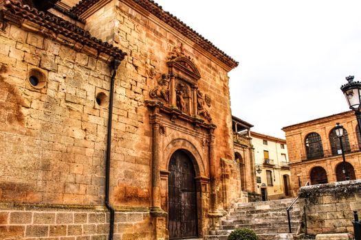 Beautiful Santisima Trinidad Church entrance, gothic style in la plaza Mayor in Alcaraz, Spain