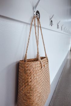 Ecology Living Zero Waste and Sustainable Concept, Straw Natural Material Women Hand Bag Hanging on Hooks in Front of Resting Room. Reusable and Eco Friendly of Women Fashion Bag Accessories