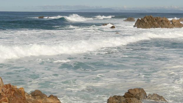 Ocean waves and rocks, Monterey, Northern California, USA. 17-mile drive near Big Sur, seaside golf tourist resort on Pacific Coast Highway. Splashing water and sea breeze of Pebble beach. Road trip.