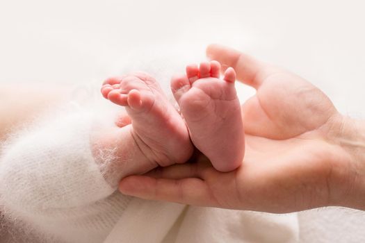 Children's feet in hold hands of mother and father. Mother, father and Child. Happy Family people concept. High quality photo