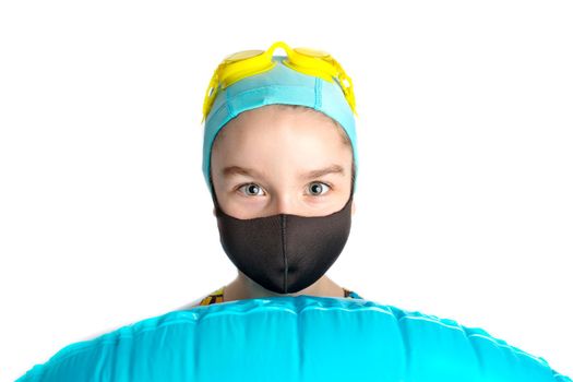 A girl in a black protective mask and an inflatable turquoise swimming circle. High quality photo