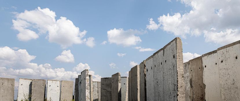 Old concrete slabs standing on a summer sunny day in the field. Old unfinished building