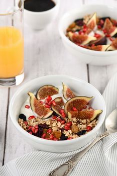 Healthy and delicious breakfast. Oatmeal muesli with Greek yogurt, fresh figs, dried fruits and pomegranate.
