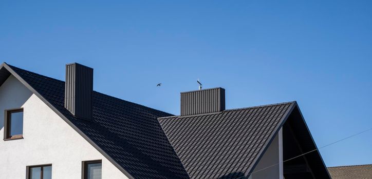 Grey corrugated metal profile roof installed on a modern house. The roof of corrugated sheet. Roofing of metal profile wavy shape. Modern roof made of metal. Metal roofing