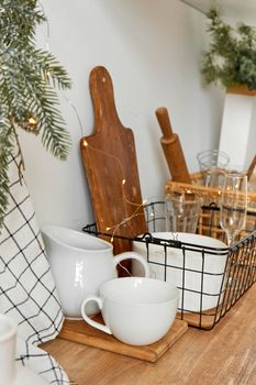 Stylish kitchen interior with white dishes and wooden furniture.