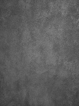 Background texture of uneven dark gray concrete or plaster wall surface