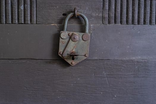Old rusty padlock on the wooden door