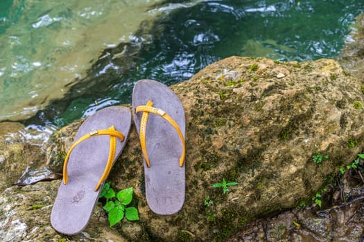 Slippers were placed on the rock in the water