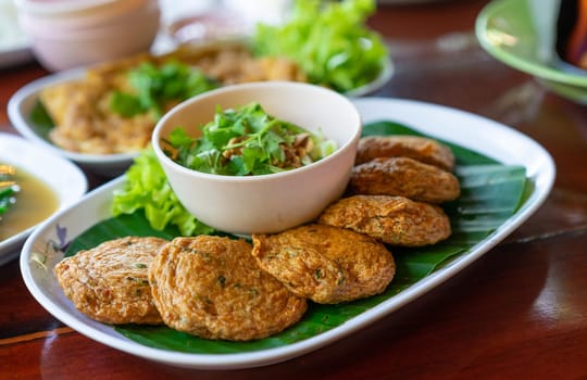 fried fish-paste balls in white dish on wooden table