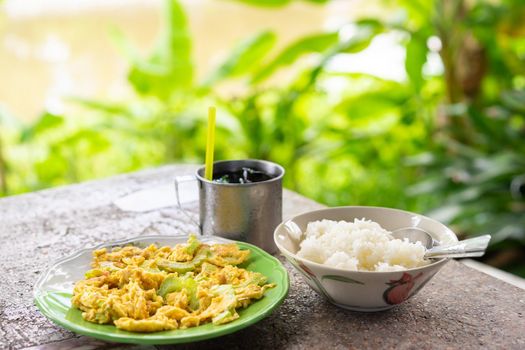 stir fried bitter gourd with egg and cooked rice on table,Thai Food