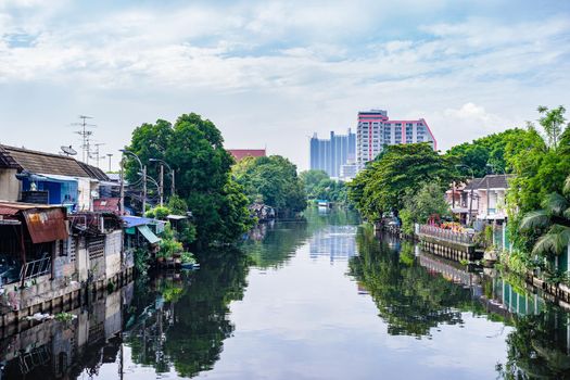 Riverside home and reflection with cloudy sky background