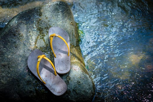 Slippers were placed on the rock in the water