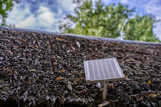 Solar panels on the thatched-roof, alternative electricity in countryside