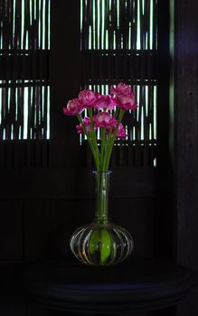 Fake flowers in a vase on wood table