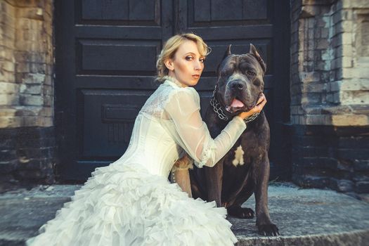 Girl in an old dress with ruffles and a big dark dog