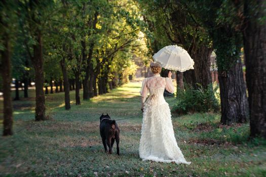 Girl in an old dress with ruffles and a big dark dog