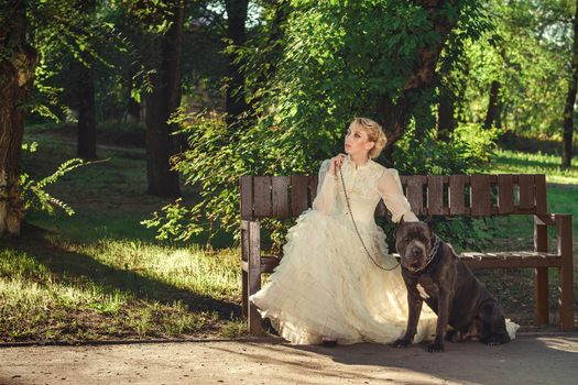 Girl in an old dress with ruffles and a big dark dog