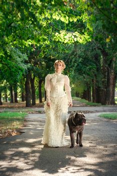 Girl in an old dress with ruffles and a big dark dog