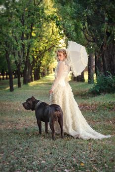 Girl in an old dress with ruffles and a big dark dog