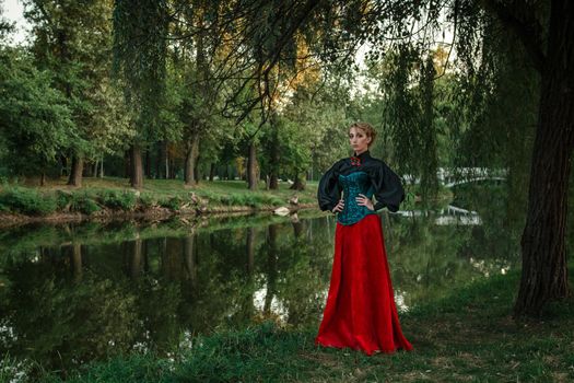 Girl model with white hair in a retro dress with ruffles in a green park