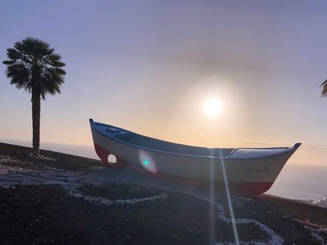 Boat and palm tree on sunset. Tenerife. Los Gigantes. High quality photo
