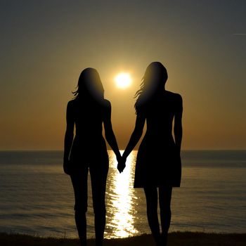 Back view of two women on holiday travel vacation beach watching sunrise