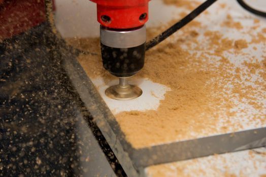 Drilling a hole for a hinge on a furniture door. Selective focus. Close up.