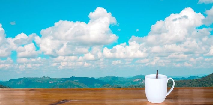 coffee cup on wooden table There is a sky background.