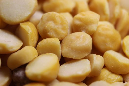 Yellow chickpea lentils seeds macro closeup view. Chana daal or yellow split peas spread background
