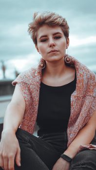 Young woman with trendy short blonde hair outdoor portrait at city