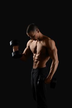 Devoted sportsman. Vertical shot of a hot and sexy shirtless muscular man posing on black background with dumbbells in his hands