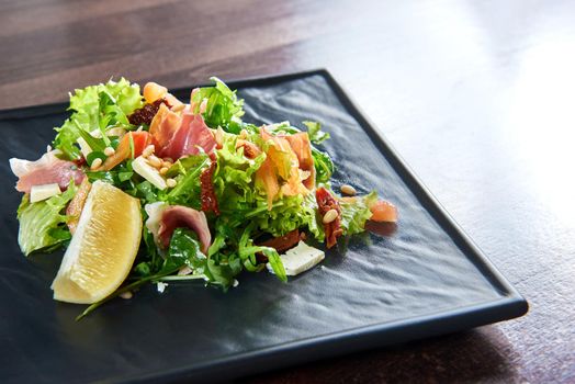 Eating healthy. Closeup of a prosciutto or jamon salad with arugula lemon dorblu cheese and pine nuts copyspace