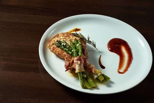 Healthy nutrition. Closeup of a delicious grilled steak with asparagus and bacon