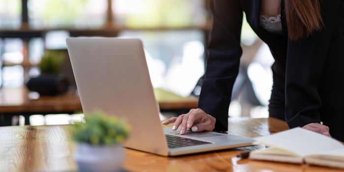 Close up woman using laptop computer on workplace.