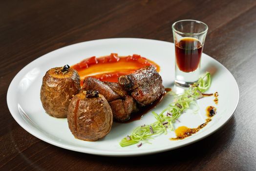 Cuisine on point. CLoseup of delicious spicy pork ribs served with smoked potatoes at the restaurant