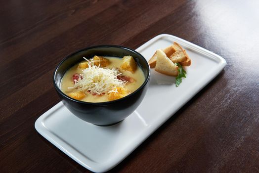 The Cheese soup. Top view of a delicious cheese soup with salami and croutons