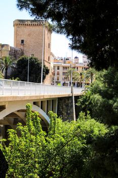 Elche, Alicante, Spain- July 2, 2021: Beautiful Altamira Palace and Altamira bridge next to Lush landscape of the Vinalopo riverbed in Elche, Alicante.