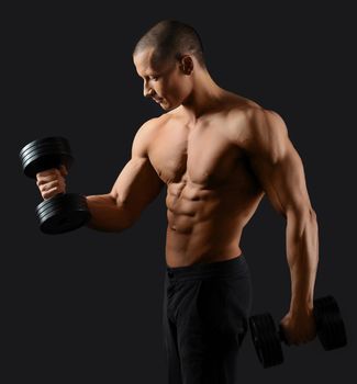 Ironman. Young handsome bodybuilder showing off his sexy ripped body working out with weights