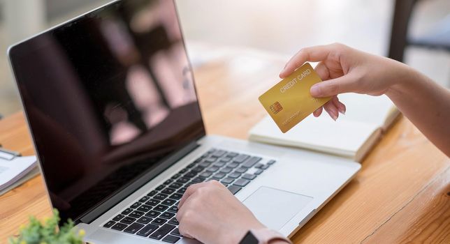 Online payment,Young woman's hands using computer and hand holding credit card for online shopping.
