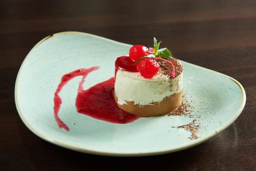 Sweet cherry. Delicious sweet cherry cheesecake served on a rustic plate at the local restaurant