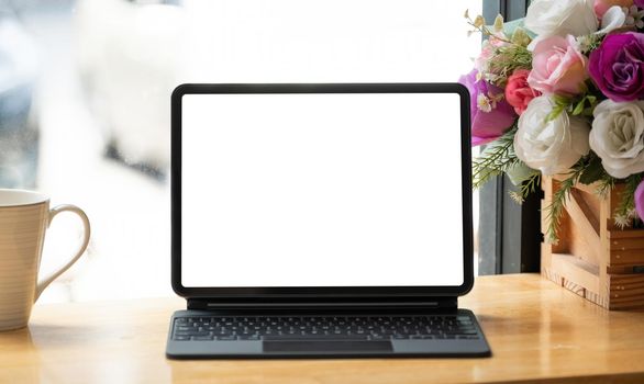 Digital tablet with keyboard with blank screen in coffee shop cafe.