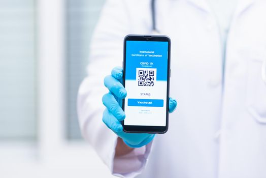 Doctor man in medical mask show app smartphone mobile digital vaccinated passport coronavirus (COVID-19) certificate to confirm, vaccine health pass concept